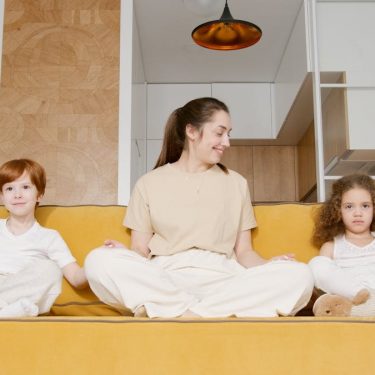 A joyful family sitting together on a yellow sofa, showcasing a comfortable and relaxed atmosphere at home.